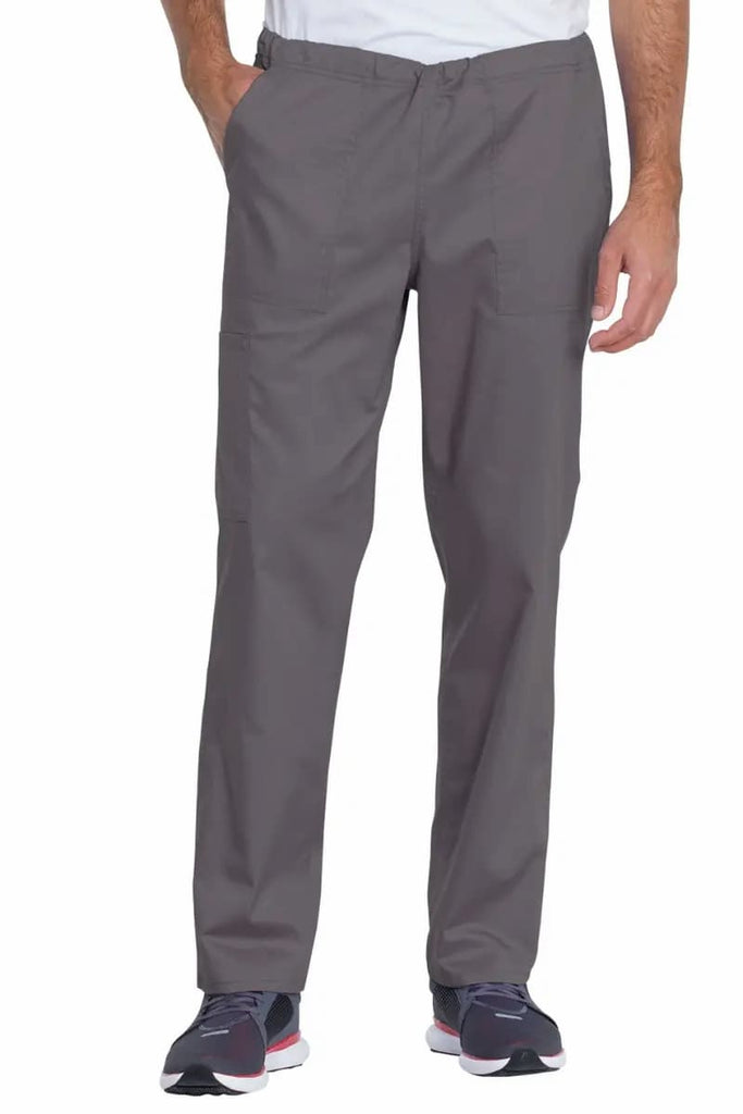 A male Pharmacy Technician wearing a Dickies Industrial Unisex Mid Rise Scrub Pant in Pewter featuring a straight leg design that offers unrestricted movement all day long. 