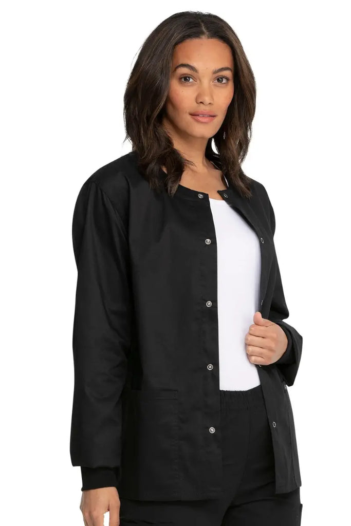 A young female LPN wearing a Dickies Industrial Unisex Warm-Up Jacket in Black size Small featuring rib knit cuffs for a snug and comfortable fit.