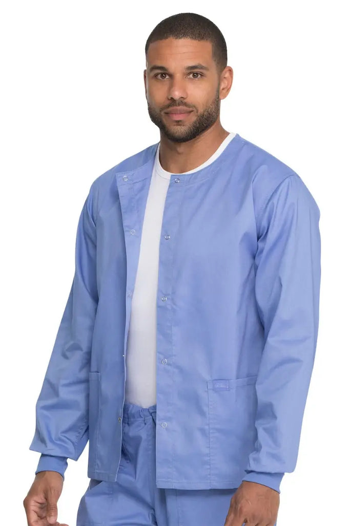 A young male Respiratory Therapist wearing a Dickies Industrial Unisex Warm-Up Scrub Jacket in Ceil Blue featuring a rib knit hem for a snug and comfortable fit that keeps out drafts.