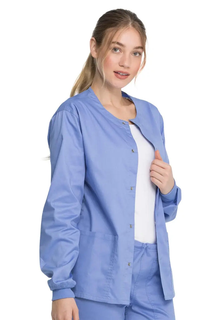A young female Dentist wearing a Dickies Industrial Unisex Warm-Up Jacket in Ceil Blue size Medium featuring rib knit cuffs for a snug and comfortable fit.