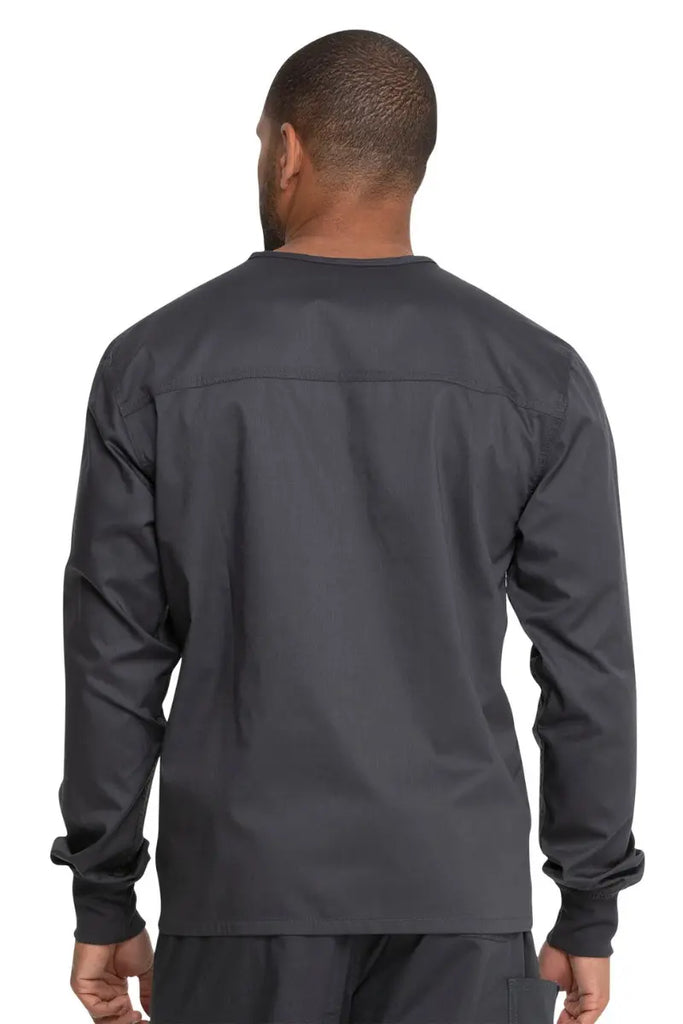 A young male Sonographer showcasing the back of the Dickies Unisex Warm-Up Scrub Jacket in Pewter featuring a flattering silhouette for all body types.
