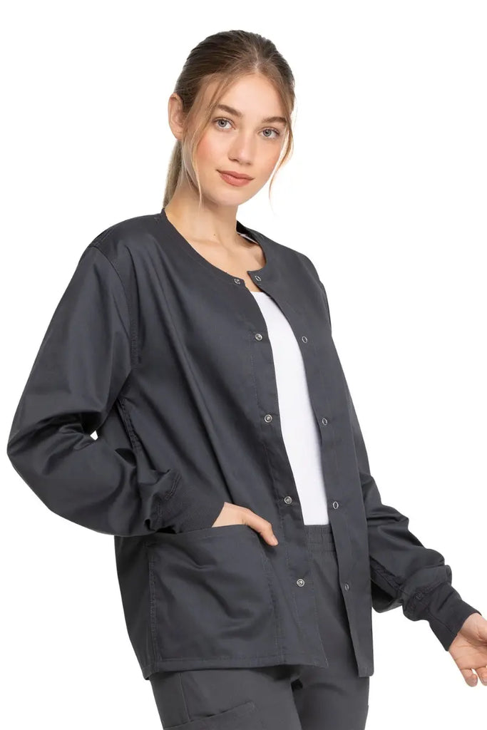 A young female Pharmacy tech wearing a Dickies Industrial Unisex Warm-Up Jacket in Pewter size XS featuring rib knit cuffs for a snug and comfortable fit.