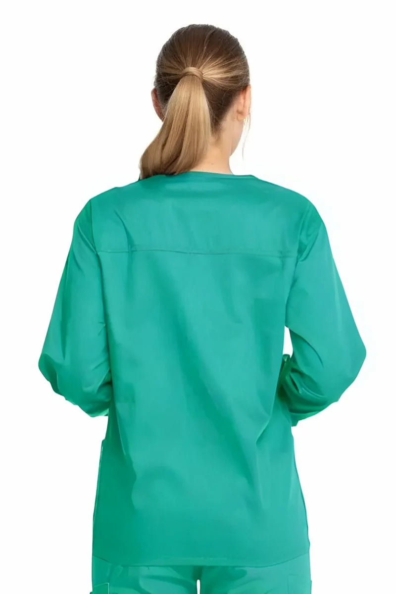 A young female CRNA showcasing the back of the Dickies Industrial Unisex Warm-Up Scrub Jacket in Surgical Green featuring a center back length of 29".