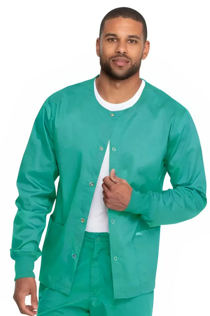 A young male Surgical Technologist wearing a Dickies Industrial Unisex Warm-Up Jacket in Surgical Green size 3XL featuring an easy care fabric made to withstand industrial laundering.