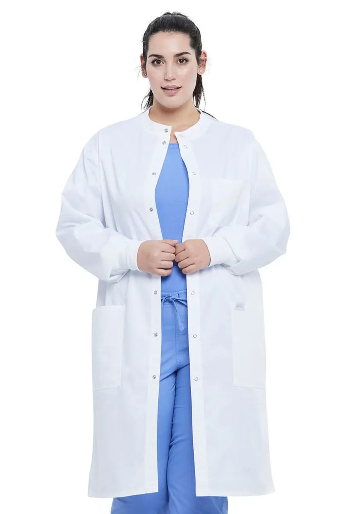 A young female Physician wearing a Dickies Industrial Unisex Snap Front Lab Coat in White size 3XL featuring an 8 button snap front closure.