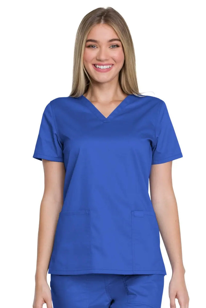 A young female Physical Therapist wearing a Dickies Industrial Women's V-Neck Scrub Top in Royal Blue size 4XL featuring a modern classic fit that provides a flattering fit all day long.