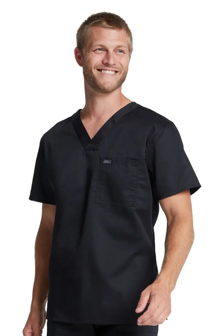 A male Radiologic Technologist wearing a Dickies Industrial Unisex Tuckable Scrub Top in Black size XL featuring a V-Neckline and short sleeves.