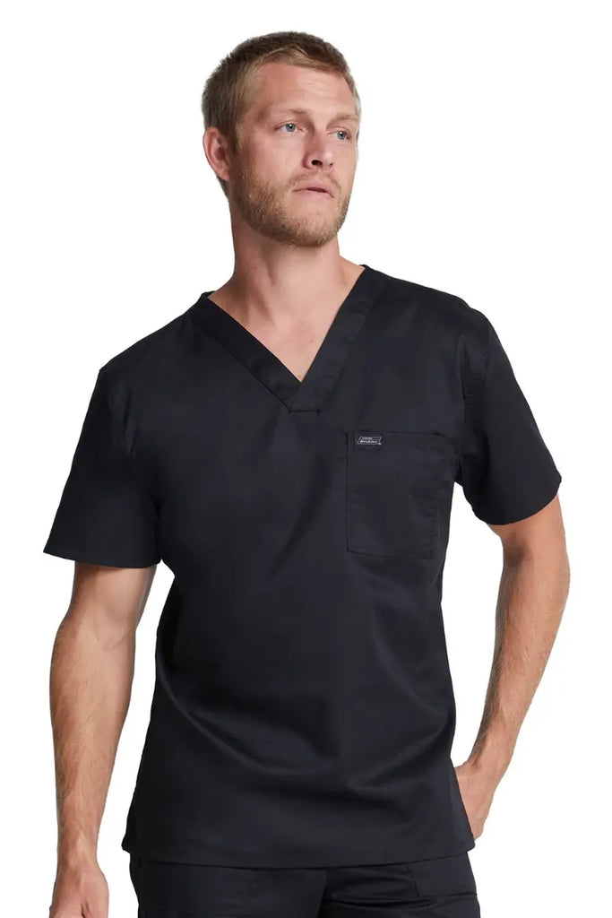 A male Medical Assistant wearing a Dickies Industrial Tuckable V-Neck Scrub Top in Black size 5XL featuring a tailored unisex fit to provide a flattering fit for multiple body types.