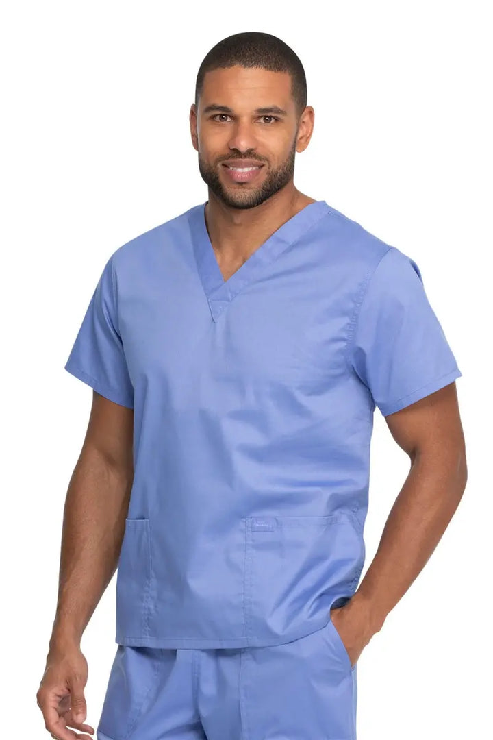 A young male Advanced Practice Provider wearing a Dickies Industrial Unisex V-Neck Scrub Top in Ceil Blue size 2XL featuring two front patch pockets.