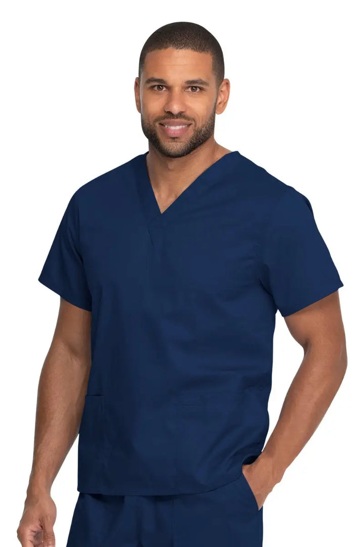 A young male Certified Nursing Assistant wearing a Dickies Industrial Unisex V-Neck Scrub Top in Navy Blue size 2XL featuring two front patch pockets.