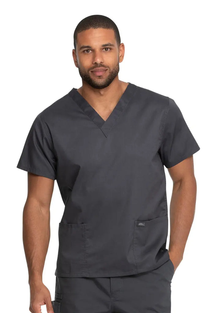 A young male Lab Technologist wearing a Dickies Industrial Unisex V-Neck Scrub Top in Pewter size 5XL featuring a soft and breathable fabric that offers all-day comfort.