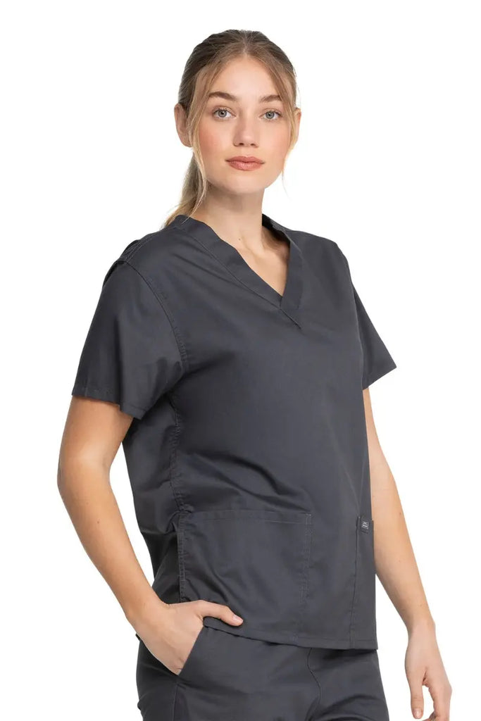A young female MRI Technologist wearing a Dickies Industrial Unisex V-Neck Scrub Top in Pewter size XS featuring a flattering fit that ensures a comfortable and professional fit for men and women.