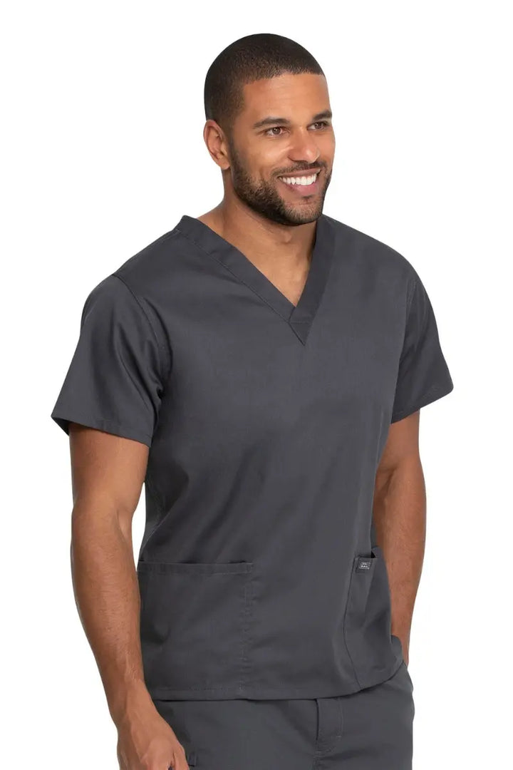 A male Medical Technician wearing a Dickies Industrial Unisex V-Neck Scrub Top in Pewter size 4XL featuring reinforced seams at stress points to provide extra strength and prevent tearing.