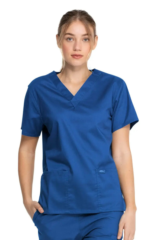 A young female Physician's Assistant wearing a Dickies Industrial Unisex V-Neck Scrub Top in Royal Blue size XXS featuring short sleeves.