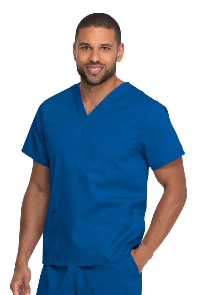 A young male Nurse Practitioner wearing a Dickies Industrial Unisex V-Neck Scrub Top in Royal Blue size 2XL featuring two front patch pockets.
