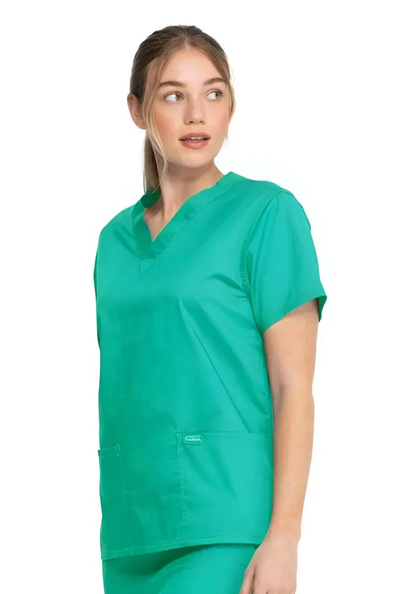 A young female Anesthesiologist wearing a Dickies Industrial Unisex V-Neck Scrub Top in Surgical Green size XS featuring a flattering fit that ensures a comfortable and professional fit for men and women.