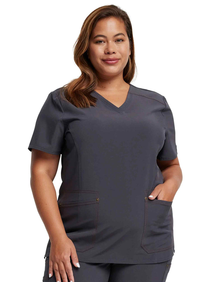 A young female Lab Tech wearing a Dickies Riveting Women's V-neck Scrub Top in Pewter featuring short sleeves.