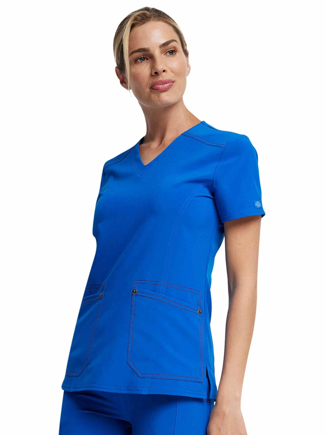 A young female Physical Therapist wearing a Dickies Riveting Women's V-neck Scrub Top in Royal Blue size Small featuring short sleeves.