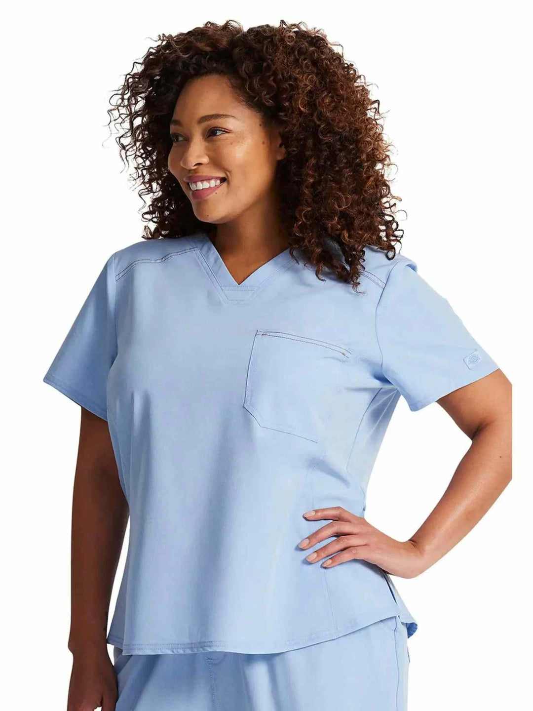 A look at the right side of the Dickies Riveting Women's Tuckable Scrub Top in Light Chambray size 3XL featuring featuring a V-neckline.