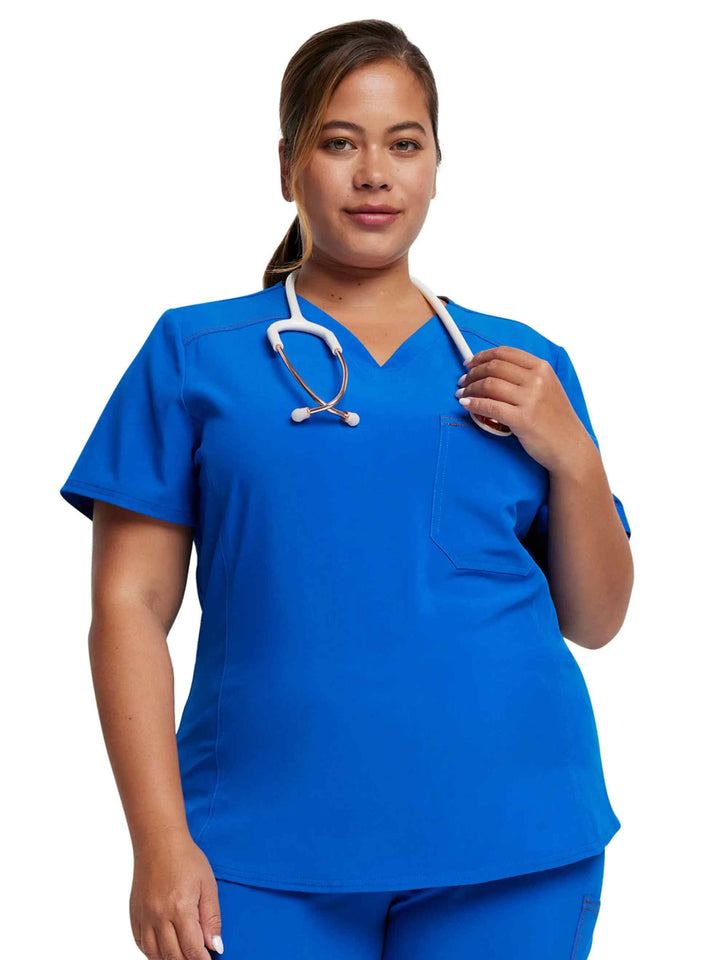 A young female Registered Nurse wearing a Dickies Riveting Tuckable V-neck Scrub Top  in Royal Blue size 3XL featuring a v-neckline.