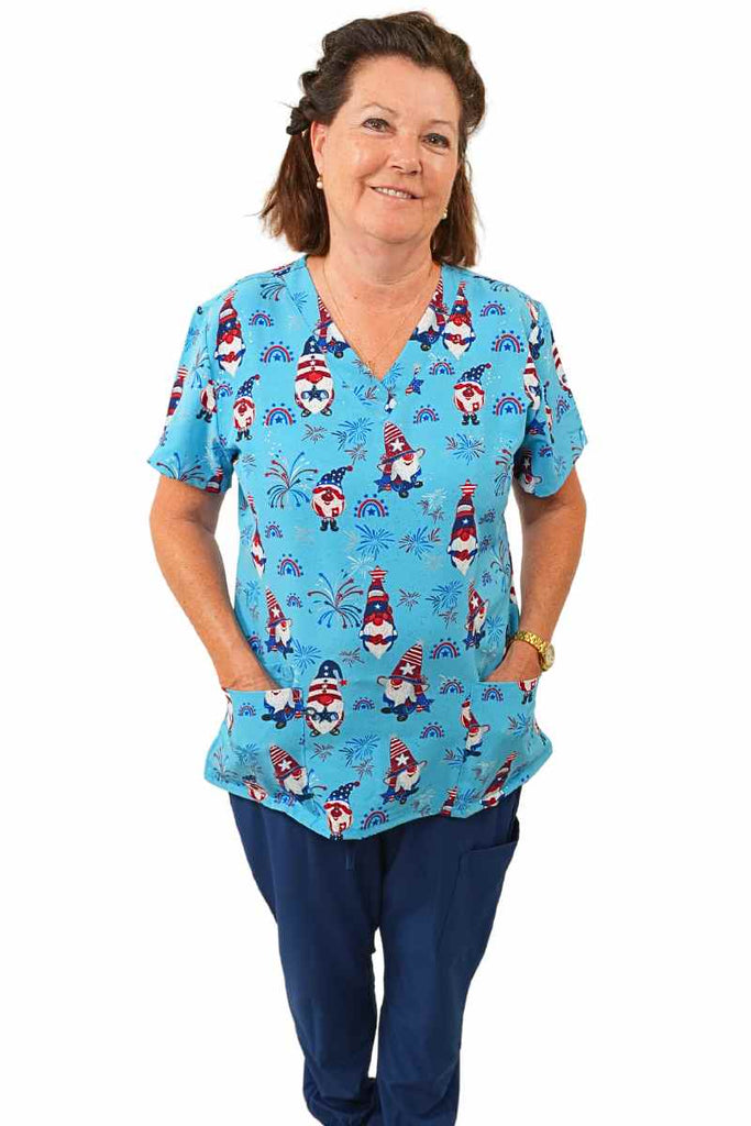 A female LPN wearing a Luv Scrubs by Med Works Women's Print Scrub Top in "Star Spangled Gnomes" size Medium featuring a total of 3 pockets for maximum storage space.