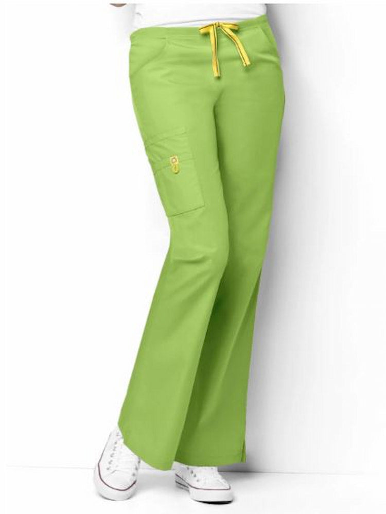 A young female family practitioner wearing a WonderWink Origins Women's Romeo Cargo Scrub Pant in Green Apple size 4XL featuring a flat front with convertible signature yellow twill tape drawstring and back elastic waistband.