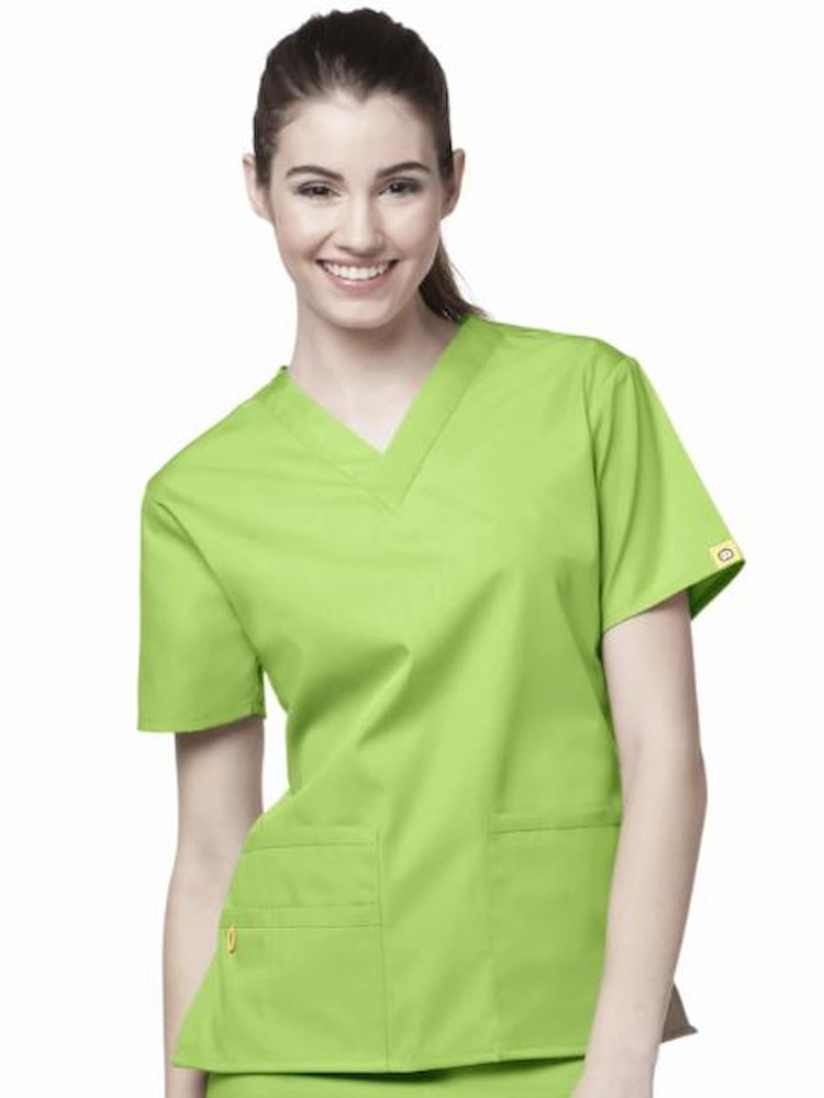 A young female Surgeon's Assistant wearing a WonderWink Women's Bravo Scrub Top in Green Apple size Large featurings short sleeves, a modern fit and vented sides.