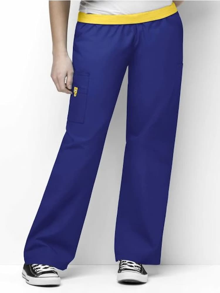 A young female LPN wearing a pair of Women's Elastic Scrub Pants from WonderWink Origins in Galaxy Blue featuring a fully elastic waistband.