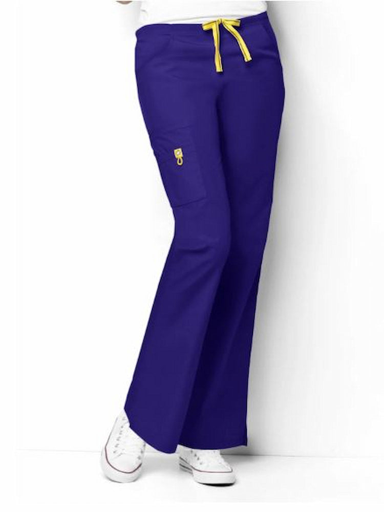 A young female Physical Therapist wearing a WonderWink Women's Romeo Cargo Scrub Pant in Galaxy Blue size XXS Petite featuring a mid rise & modern fit.
