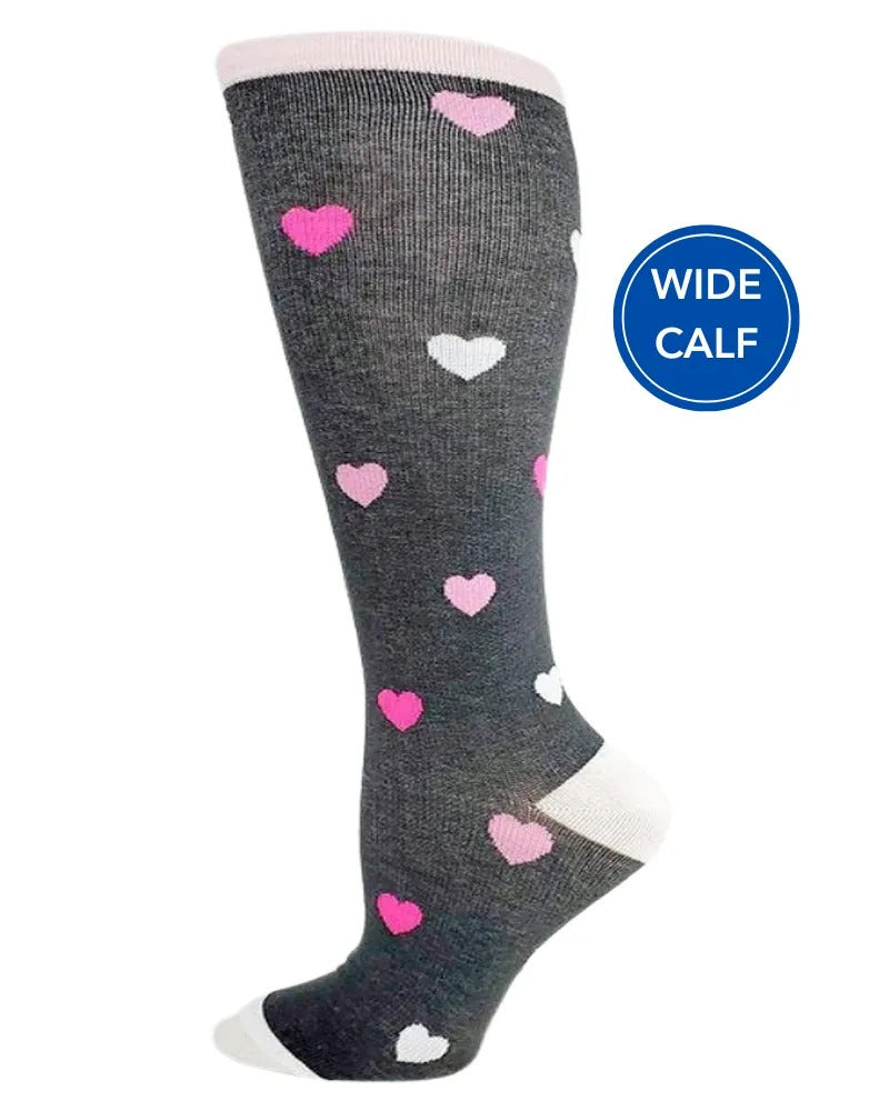 Foot mannequin displaying Pro-Motion Women's Wide Calf Compression Socks in grey with white, pink & hot pink hearts featuring a calf size of 17"-21".
