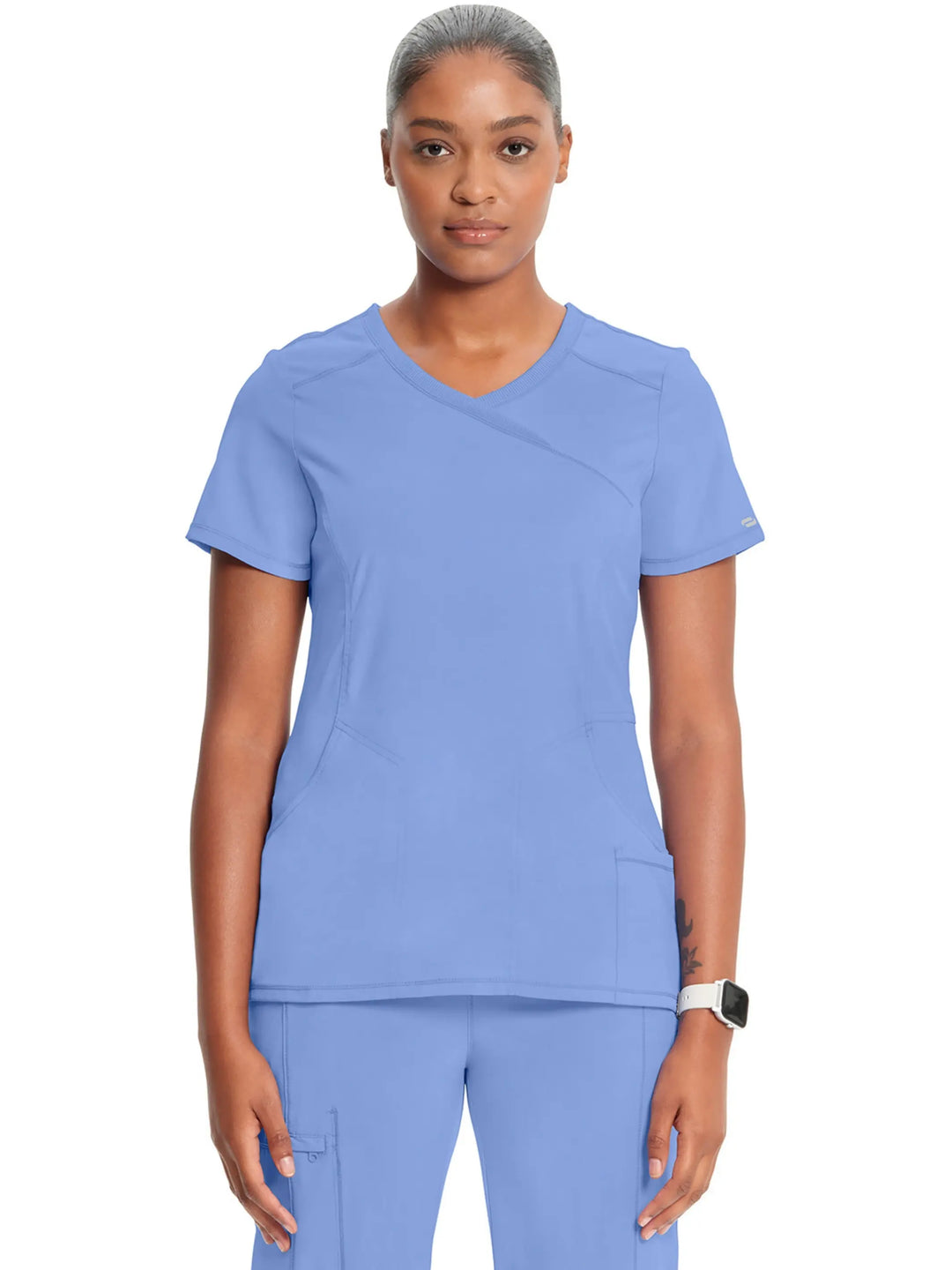 A look at the front of the Infinity Women's Mock Wrap Scrub Top (2625A) in Ceil Blue featuring stylish seaming throughout and three pockets.