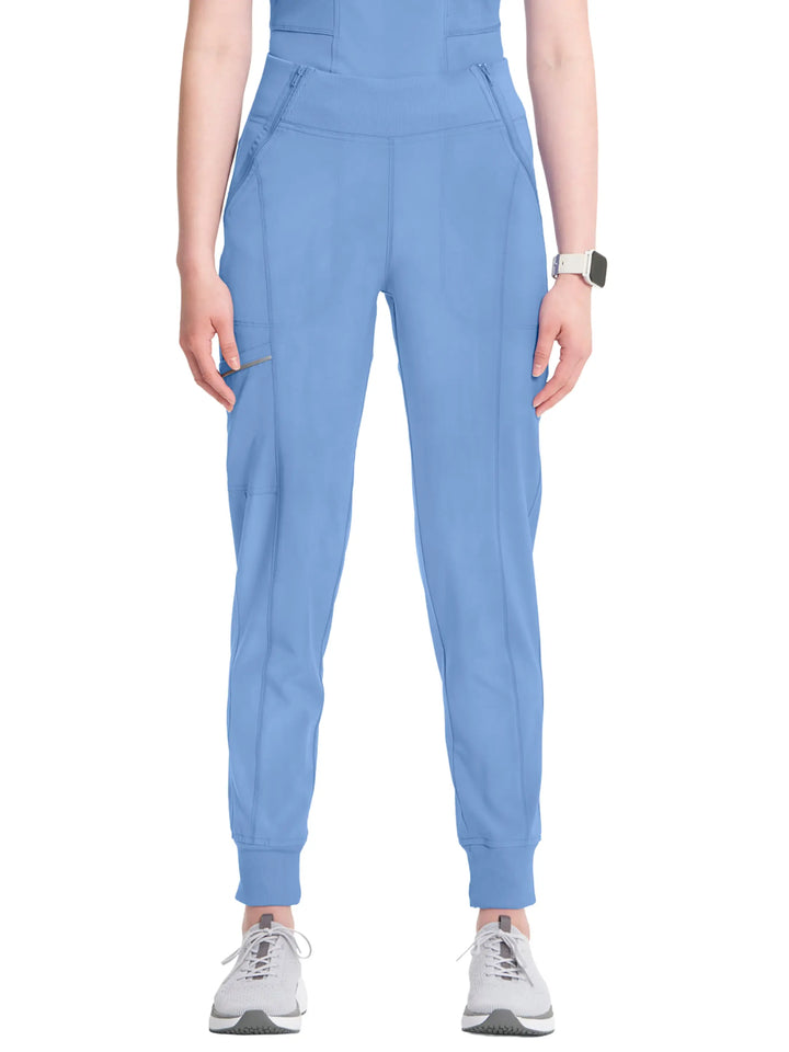 A young female Dental Assistant wearing an Infinity Women's' Mid Rise Tapered Jogger in Ceil Blue featuring rib knit leg bands for an adjustable fit.