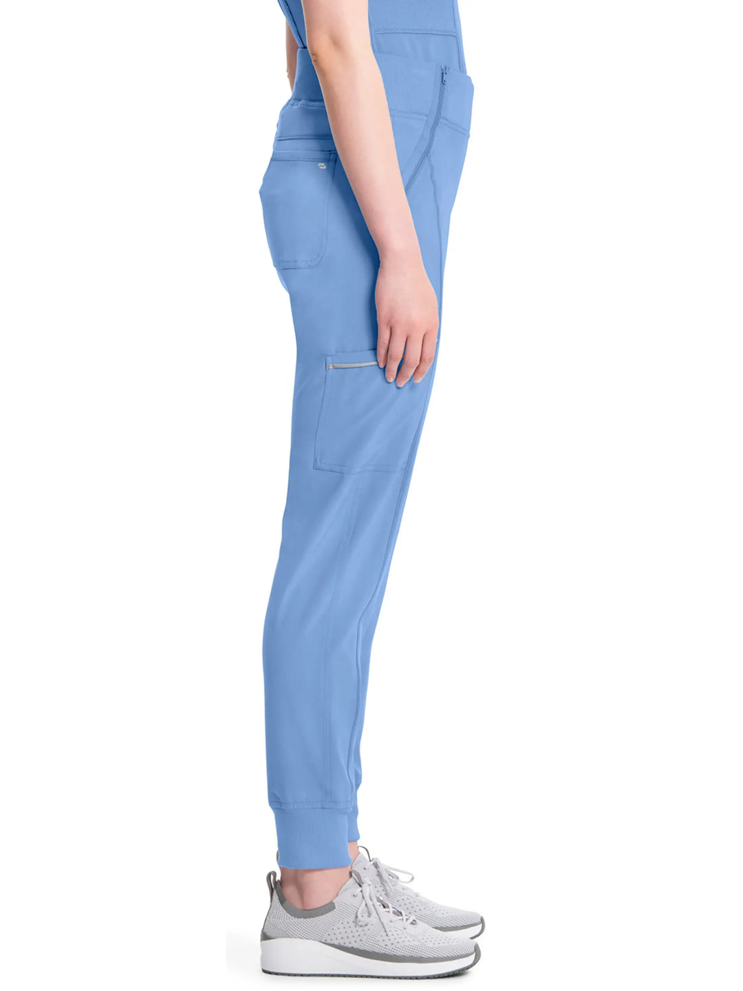 A look at the side of the Infinity Women's Mid-Rise Tapered Scrub Jogger in Ceil Blue size medium featuring a cargo zipper pocket on the wearer's right side. 