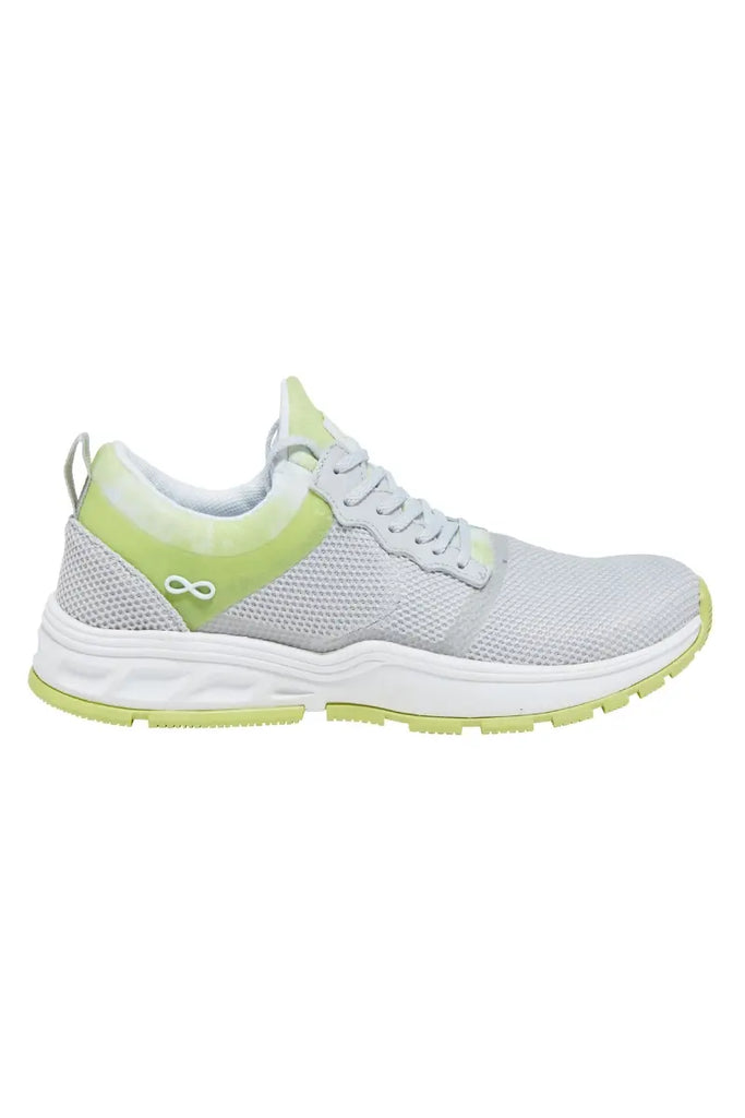 The outside of the Infintiy women's Fly Athletic Nurse Shoe in Cloudy Lime size 6 featuring a metal logo on the side by the ankle.