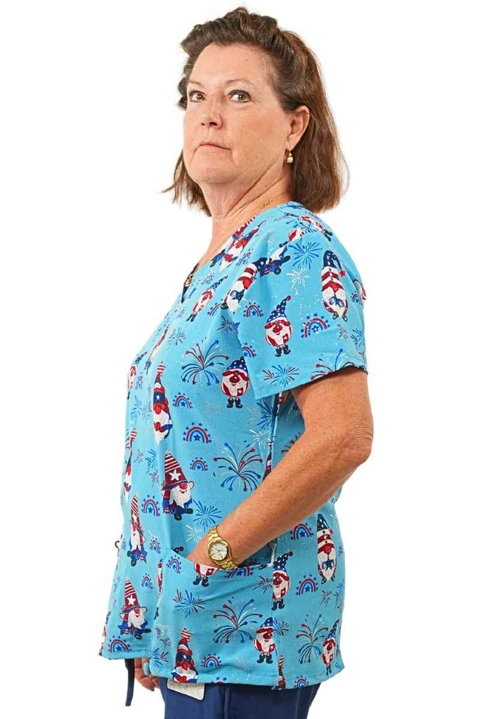 A female Veterinarian wearing a Luv Scrubs by MedWorks Print Scrub Top in "Star Spangled Gnomes" in size 2XL featuring a unique stretch fabric made of 93% Polyester, 7% Spandex.