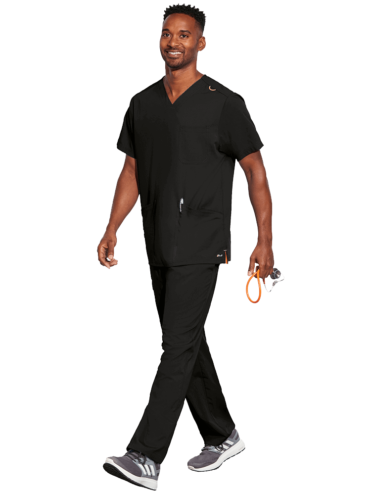 Young male LPN wearing a Unisex V-Neck Scrub Top from Barco Motion in Black size Medium featuring a total of 5 pockets for all of your daily storage needs.