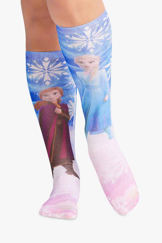 The front of the Cherokee Women's Comfort Support Socks in "My Sister" featuring Disney's favorite Anna and Elsa from Frozen on a blue and pink background.