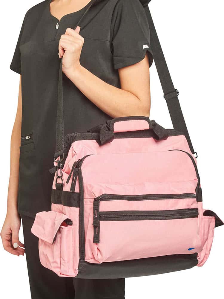 A young female CNA carrying the Nurse Mates Ultimate Medical Bag in "Blossom Pink" featuring a hardwearing shoulder strap.