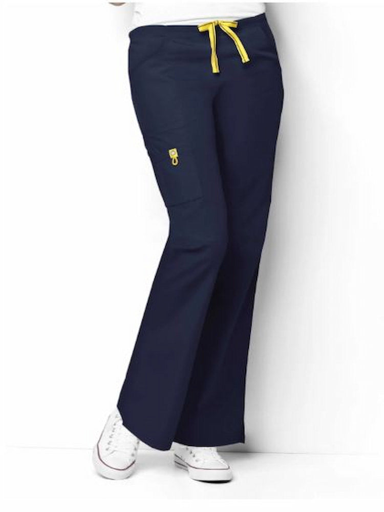 A middle aged female Registered Nurse wearing a WonderWink Origins Women's Romeo Cargo Scrub Pant in Navy size XXS featuring 1 right cargo WonderWink signature triple pocket with yellow bungee ID loop.