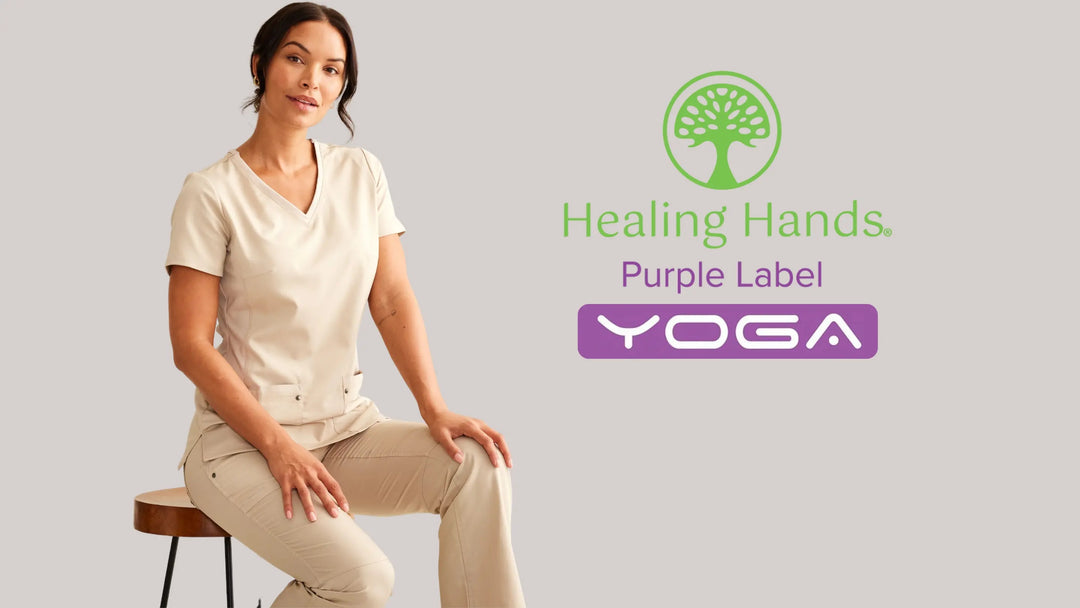 A female member of a Hospital Administration team wearing Purple Label Yoga scrubs on a light grey background. 