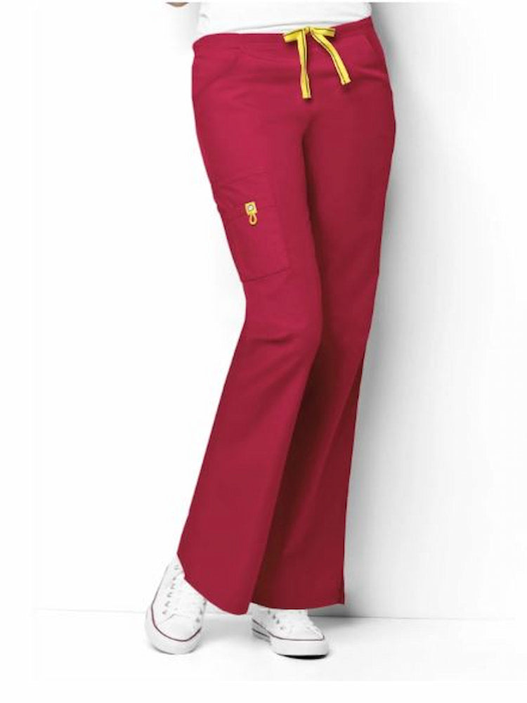 A young female LPN wearing a pair of WonderWink Origins Women's Romeo Flare Leg Scrub Pants in Red size 5XL featuring a modern fit.