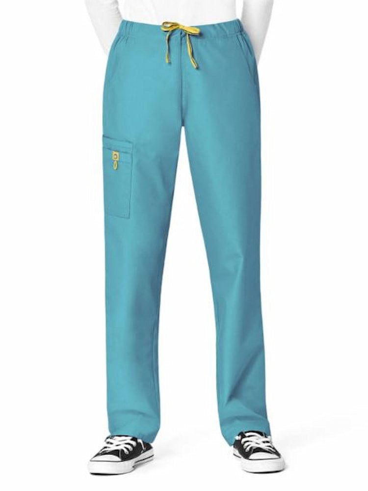 A middle aged female dental hygienist wearing a WonderWink Origins Women's Cargo Scrub Pant in Real Teal size XXS Petite featuring a convertible drawstring. 