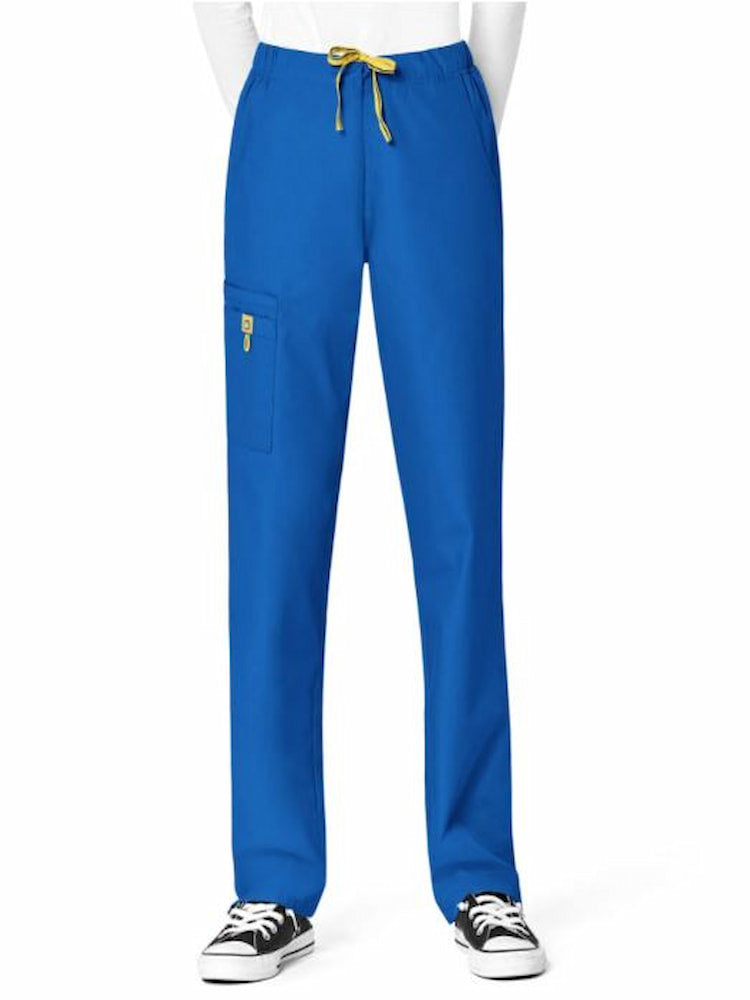 A young female physical therapist wearing a WondrWink Origins Women's Slim Leg Cargo Scrub Pant in Royal size 4XL 2 front curved pockets. 