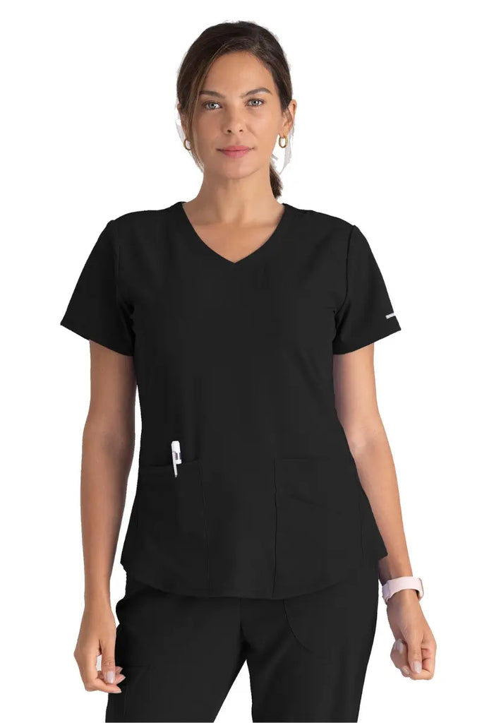A young female Physical Therapist wearing a Women's Breeze V-neck Scrub Top from Skechers in Black size Large featuring a modern fit.