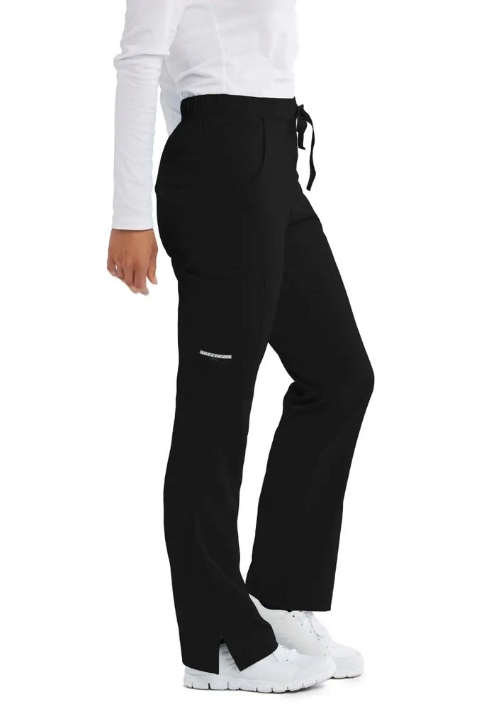 The right side of the Skechers Women's Reliance Cargo Scrub Pant in Black size medium featuring an exterioir, cargo pocket on the wearer's right side with the Skechers logo printed at the bottom of the pocket.