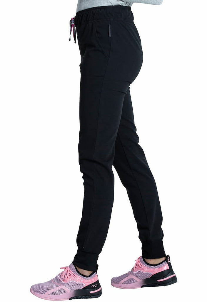 An image of a young female Physical Therapist wearing a Vince Camuto Women's Mid Rise Drawstring Jogger in Black size 2XL Petite featuring an inseam of roughly 29".