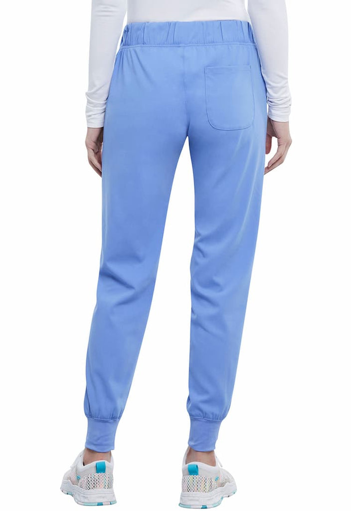 A young female Physician's Assistant Wearing a Vince Camuto Women's Mid Rise Drawstring Jogger in Ceil size Large Tall featuring a single back patch pocket on the wearer's right side.