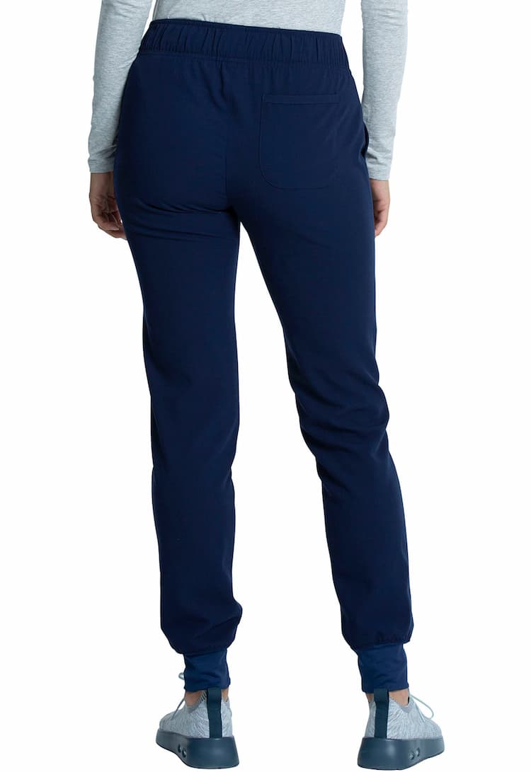A young female Physician;s Assistant Wearing a Vince Camuto Women's Mid Rise Drawstring Jogger in Navy size XS Tall featuring a single back patch pocket on the wearer's right side.