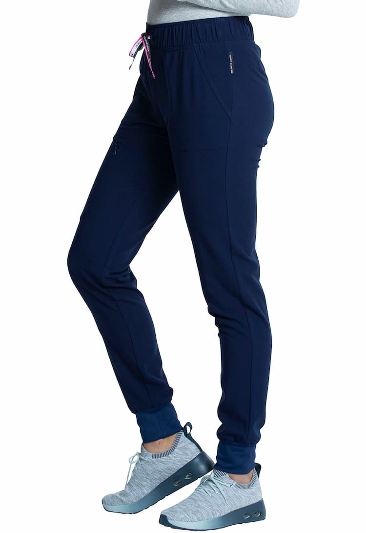 An image of a young female Physical Therapist wearing a Vince Camuto Women's Mid Rise Drawstring Jogger in Navy size Small featuring an inseam of roughly 29".