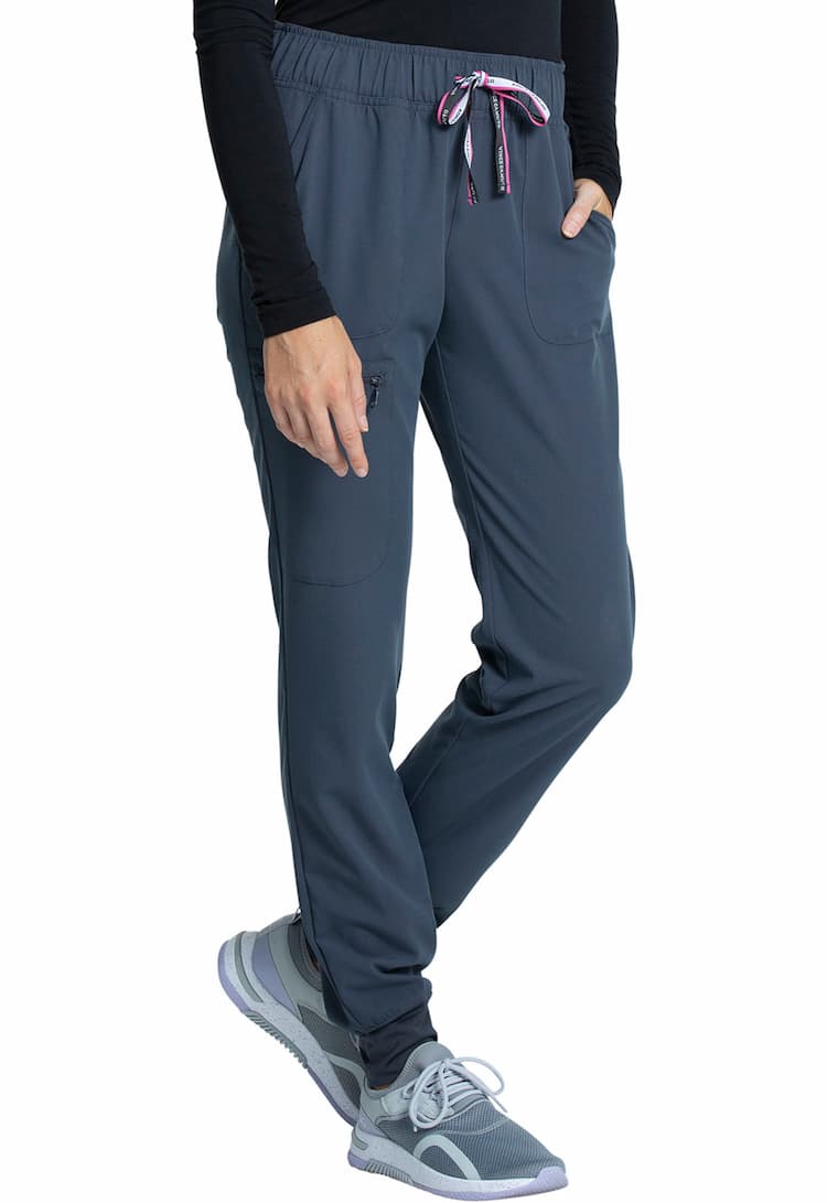A young female Medical Assistant wearing a Vince Camuto Women's Mid Rise Drawstring Jogger in Pewter size Medium featuring an outside, zipper cargo pocket on the wearer's left side.